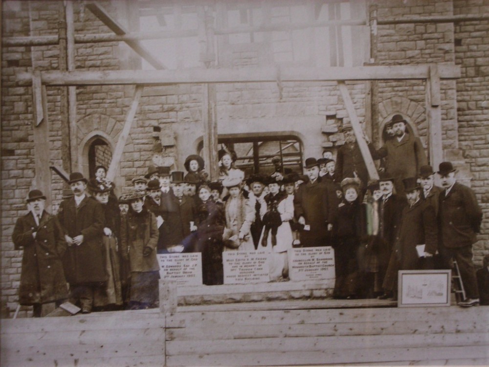 Monmouth Baptist Church building in mid construction in 1906 with members of the congregation in 1906.